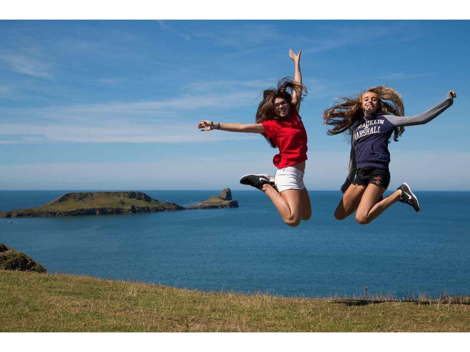 Cardiff'teki Celtic English Academy'nin önünde zıplayan iki öğrenci.