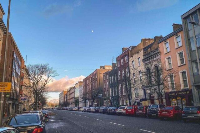 Cork şehrinde binalar ve park edilmiş araçların manzarası.